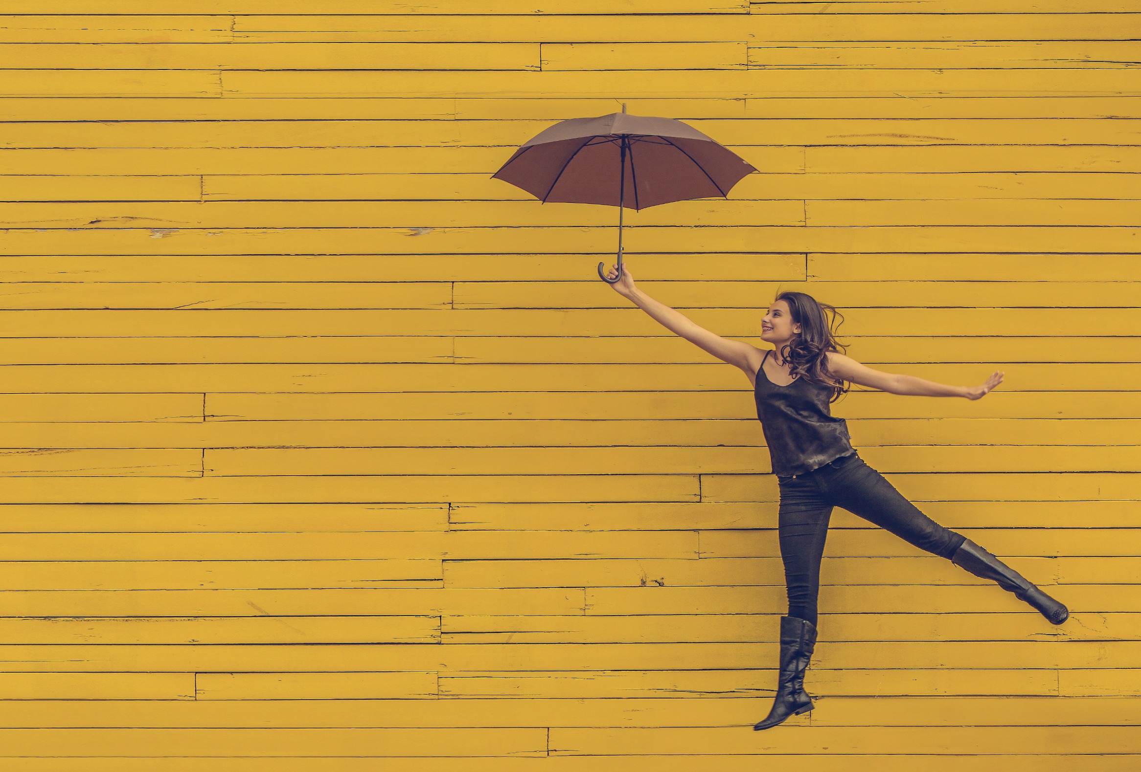 Cultivating Happiness image jumping with an umbrella